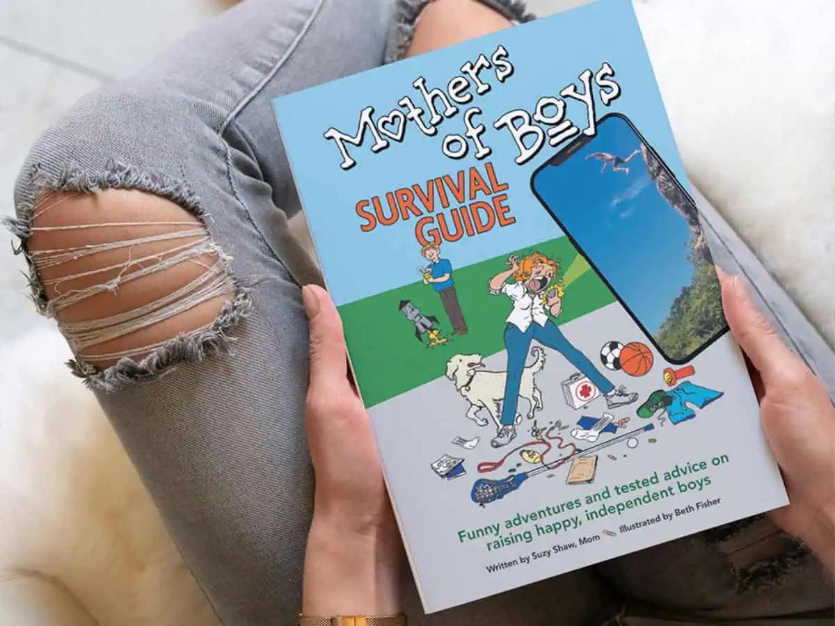 A mom holding the Mothers of Boys Survival Guide book.